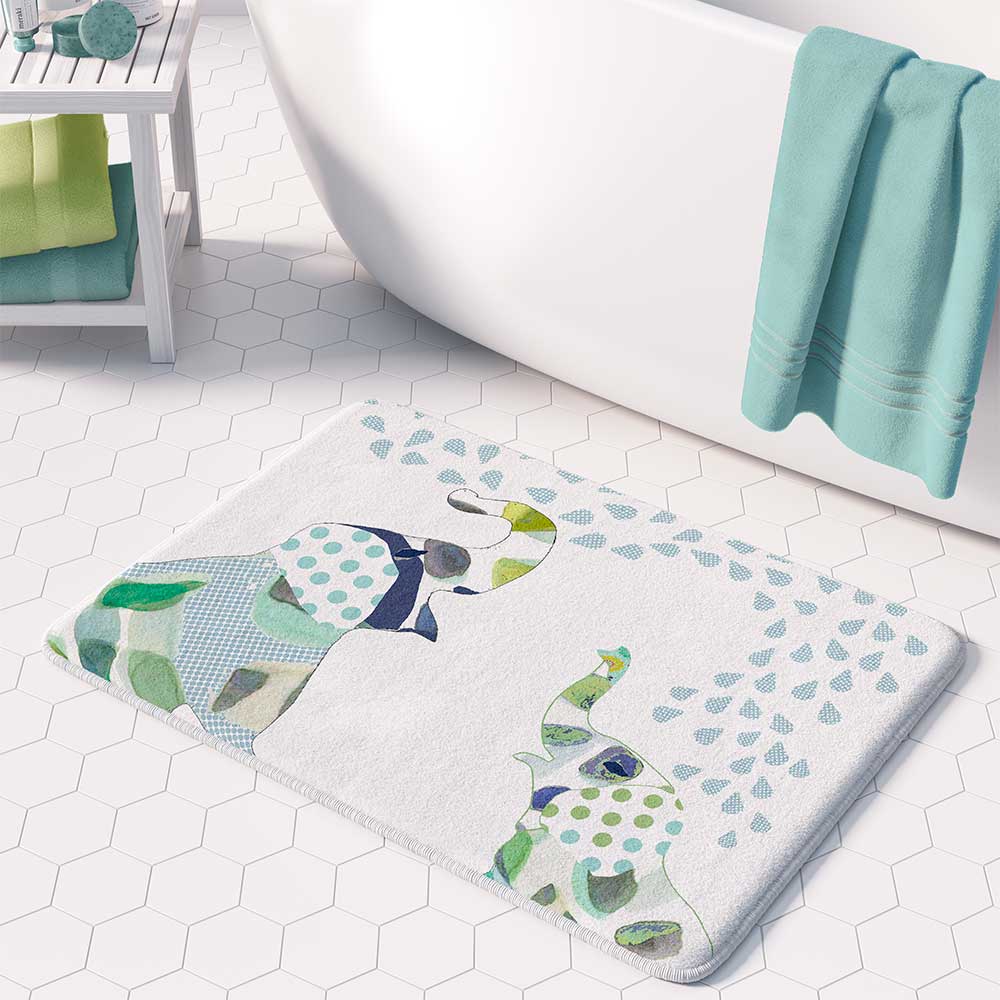 A white microfiber non slip bath mat for kids featuring a playful blue and green elephant print. Mold and mildew resistant, plush, soft, non-slip, machine washable, and quick drying.