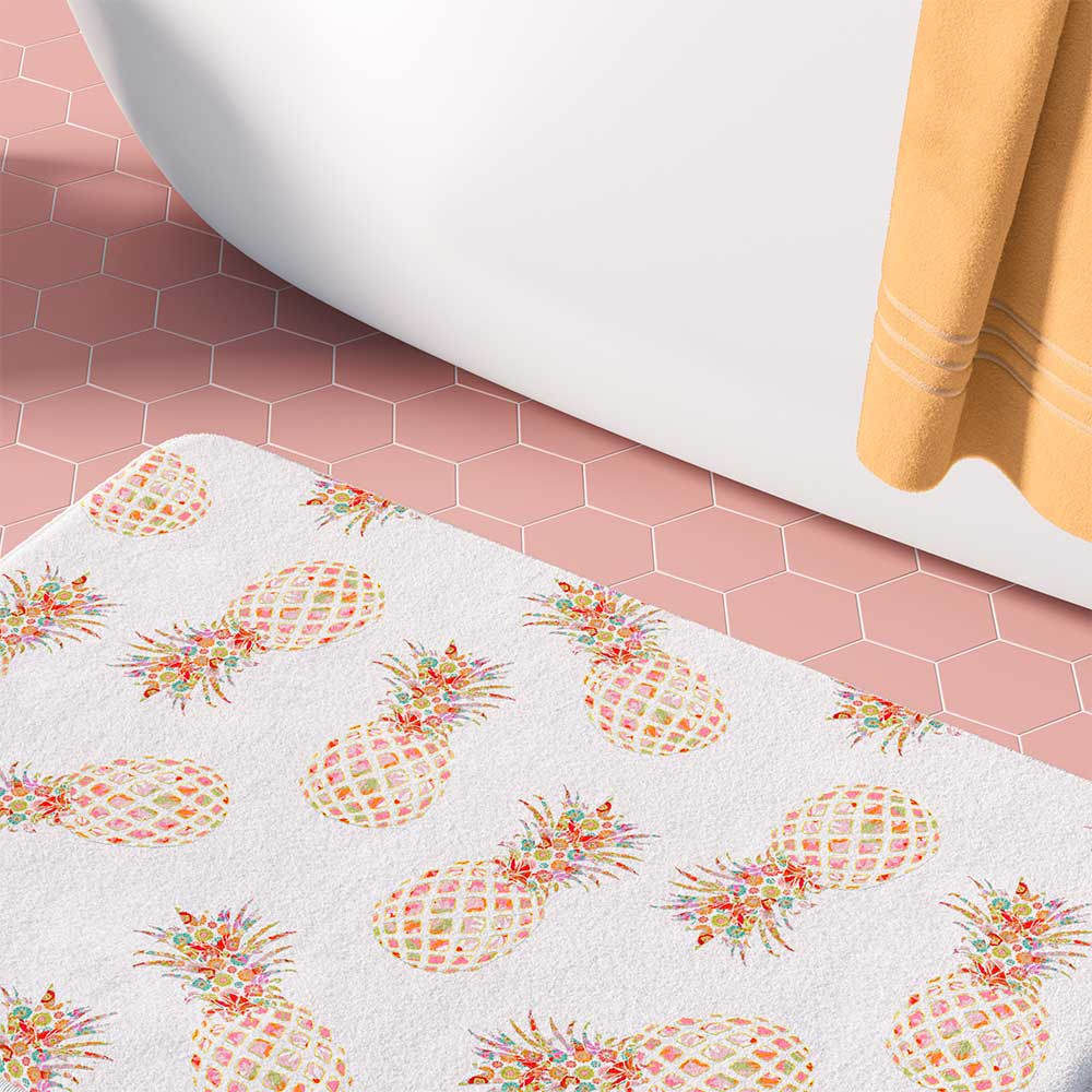 White bath mat with tropical pink and orange pineapple pattern.