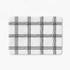 Black and white checked bath mat with artist-designed geometric pattern.