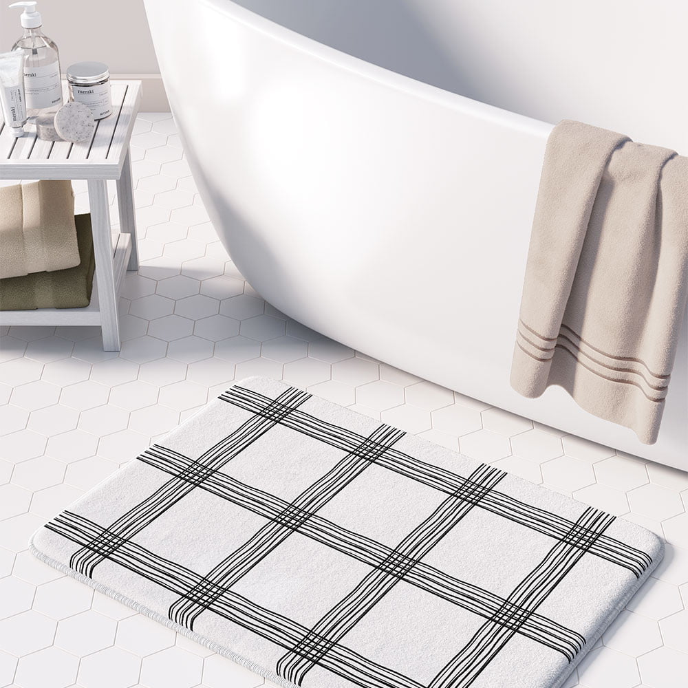 Black and white checked bath mat with artist-designed geometric pattern.
