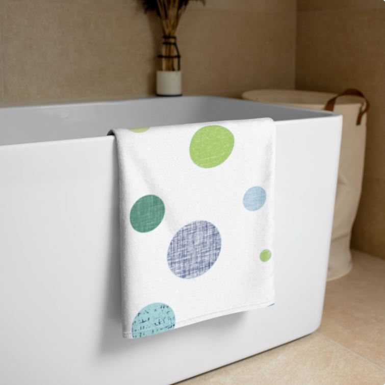 White bath towel with blue and green polka dot pattern