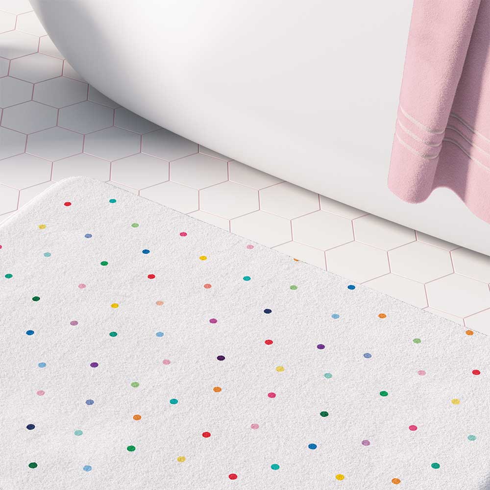 A girls' bathroom bath mat featuring tiny colorful polka dots