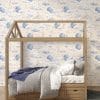 Large-scale watercolor moons and clouds wallpaper in a toddler room